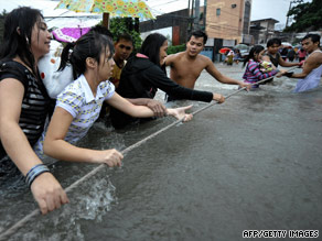 Filipino pedestrians in Quezon City, a suburb of Manila, brave Tropical Storm Ketsana's floodwaters.